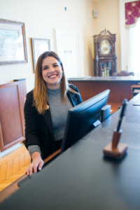 Jeune femme souriante derrière ordinateur